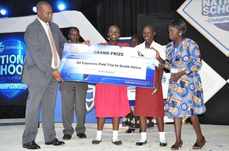Stanbic's Patrick Mweheire hands over grand prize to Muni Girls who were overall winners.