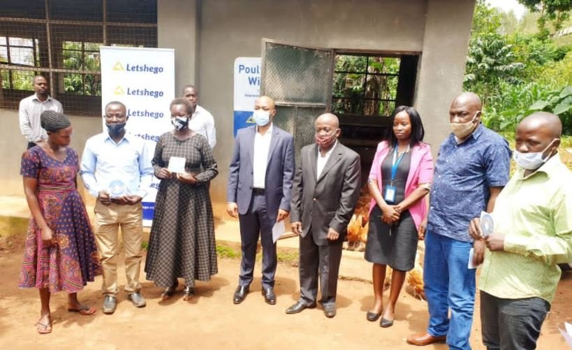 Regional farmers take a group photo with Giles Aijukwe CEO Letshego and Letshego board director Peter Masaba (Center) during ILC Poultry project handover in Wakiso district