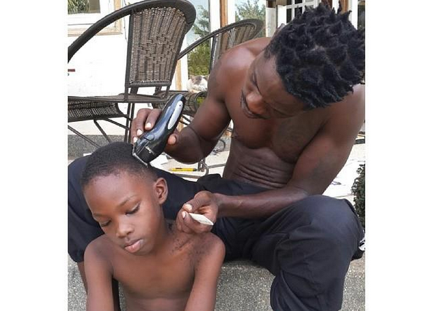 LOVELY FATHER: Bobi Wine gives his son the best hair cut ever. [Photo]