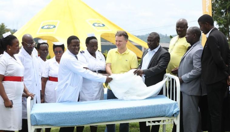 Wim Vanhelleputte the CEO MTN Uganda hands over part of the beds, blankets and mosquito nets to the staff of Kabarole Hospital. 