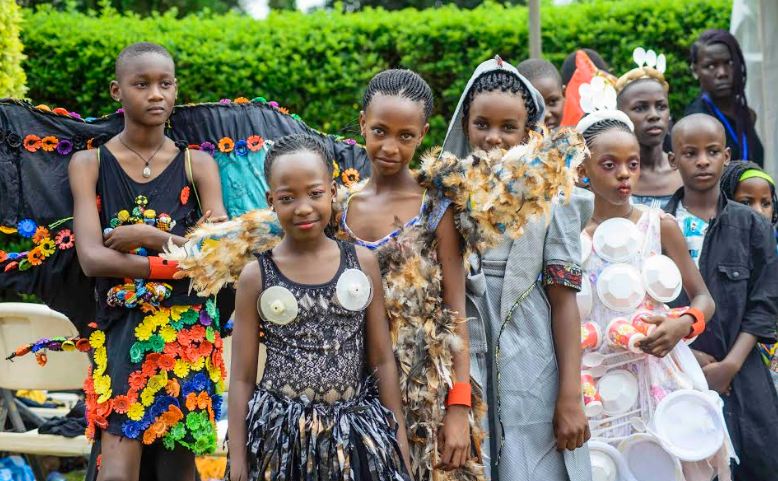 Children show off their fashion designs as produced with the FAAM Club and Njola's Ghetto Wardrobe Campaign
