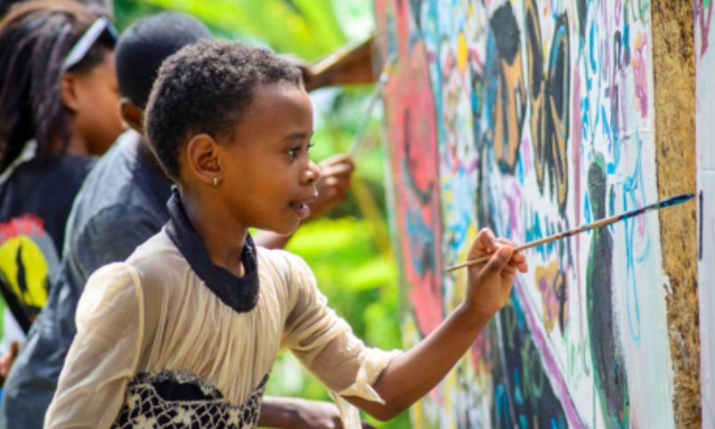 Children participate in mural painting at the Azulato Children's Festival. 
