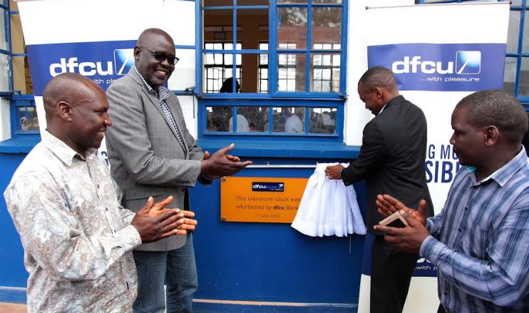 dfcu Bank's Head of Marketing, Jude Kansiime unveils the refurbished clasroom block at  Nakivubo Blue Primary School