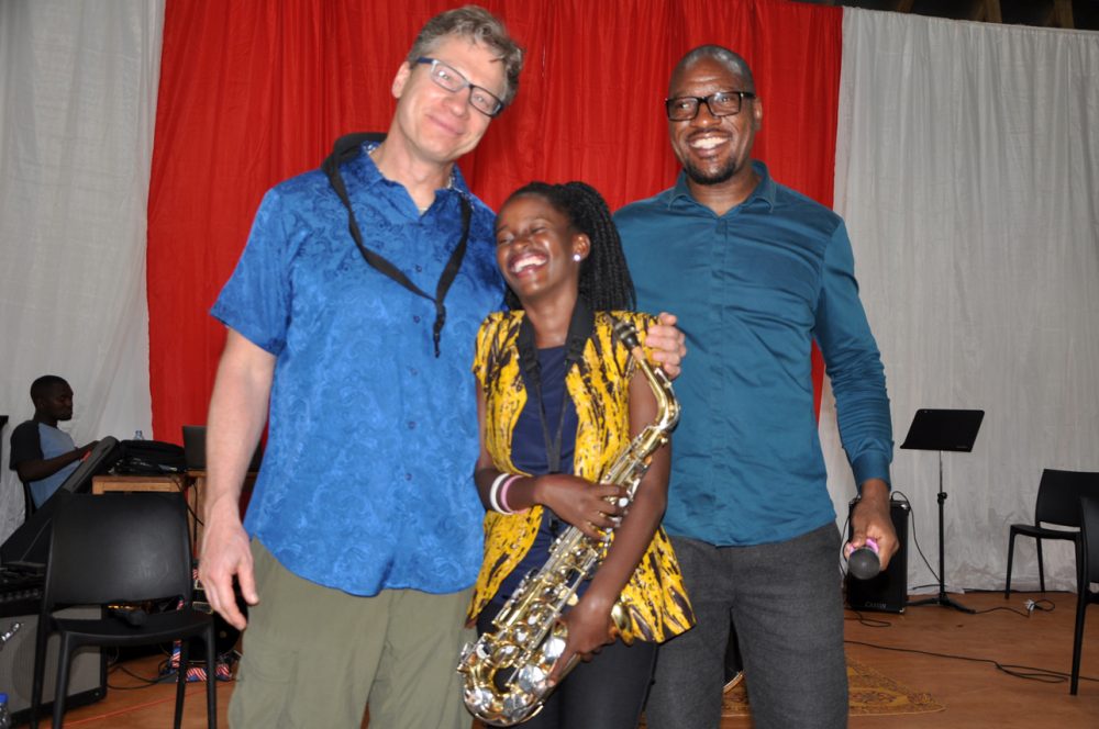 Nakijoba Lydia, a student of the African Institute of Music receives a saxophone from the facilitators.